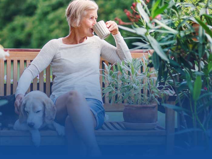 Lady sat with dog drinking coffee