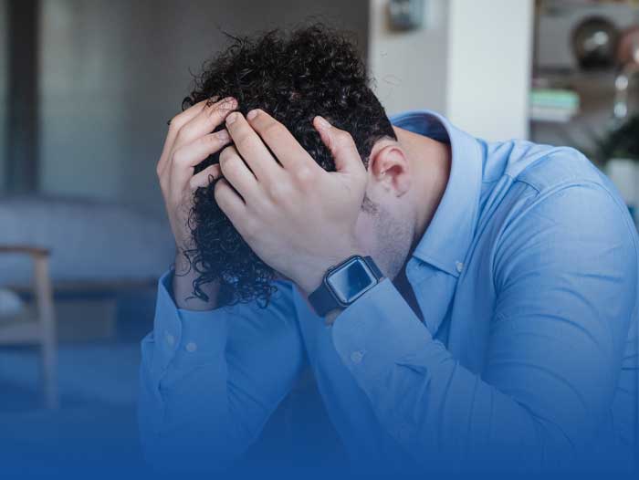 A young man holding his head in his hands as he does not have a Lasting Power of Attorney